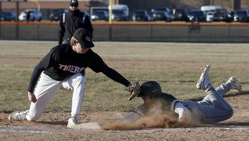 Crystal Lake Central's Mason Lechowicz tries to tag out Boylan’s Nico Contreras as he dives back to first base during a nonconference baseball game Wednesday, March 29, 2023, at Crystal Lake Central High School.