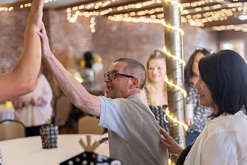 High fives and hugs all around as friends celebrate Merlin Sunday, Sept. 17, 2023.