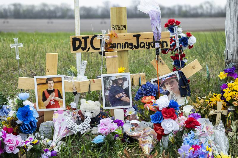 A memorial to accident victims Jayden Lee Hanson and Channing Swertfeger, both 14, and 16-year-old Douglas “DJ” Dorathy  continues to grow Tuesday, April 16, 2024 at the intersection of Luther and Hahnaman Roads in rural Whiteside County.