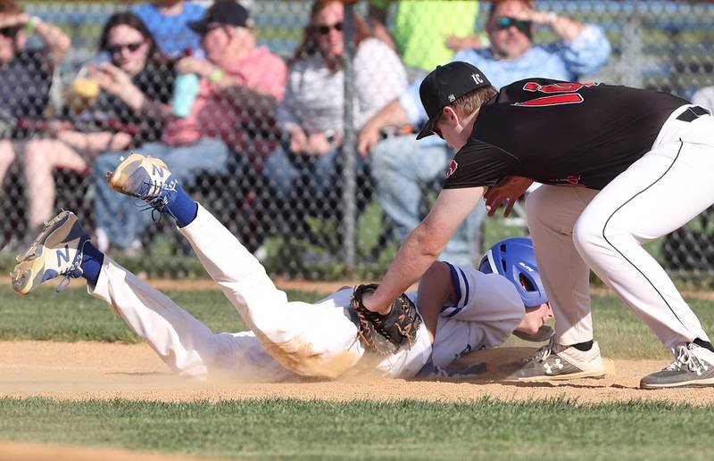 Hinckley-Big Rock's Max Hintzsche dives back safely as Indian Creek's Blake McRoberts applies the tag on a pick-off attempt Monday, May 16, 2022, at Hinckley-Big Rock High School during the play-in game to decide who will advance to participate in the Class 1A Somonauk Regional.