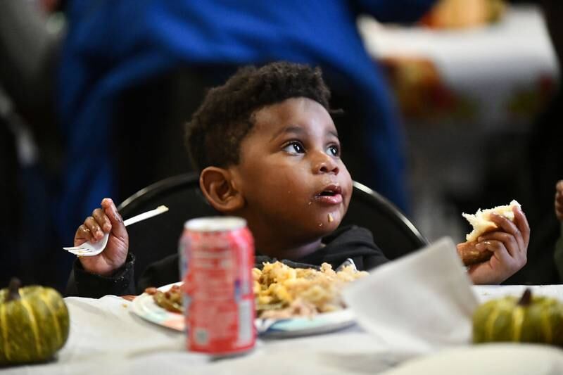 Two-year-old Leeon Key, of Kankakee, enjoys his food Wednesday during the Kankakee Salvation Army's annual Thanksgiving meal.