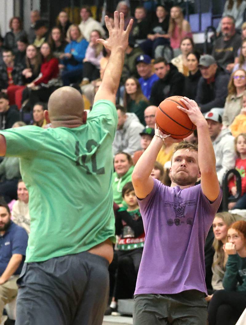 Sycamore School Staff team member Jake Winters shoots over a Fire/Police team member Thursday, Dec. 19, 2024, during the Heroes on Hardwood basketball game at Sycamore High School. The basketball game, which is a fundraiser for the Spartan Food Pantry, pits a team of Sycamore first responders against a squad of Sycamore School District 427 staff.