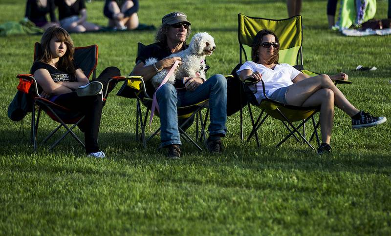 Lorraine Leonard, 13, (from left), Dr. Woods' Buddy Eiegelman and his wife Amy Wiegelman listen to the band Shinehammer on June 12, 2014, in Cary. Dr. Woods Guitar Emporium in Fox River Grove donated the sound equipment to be used during the concert.