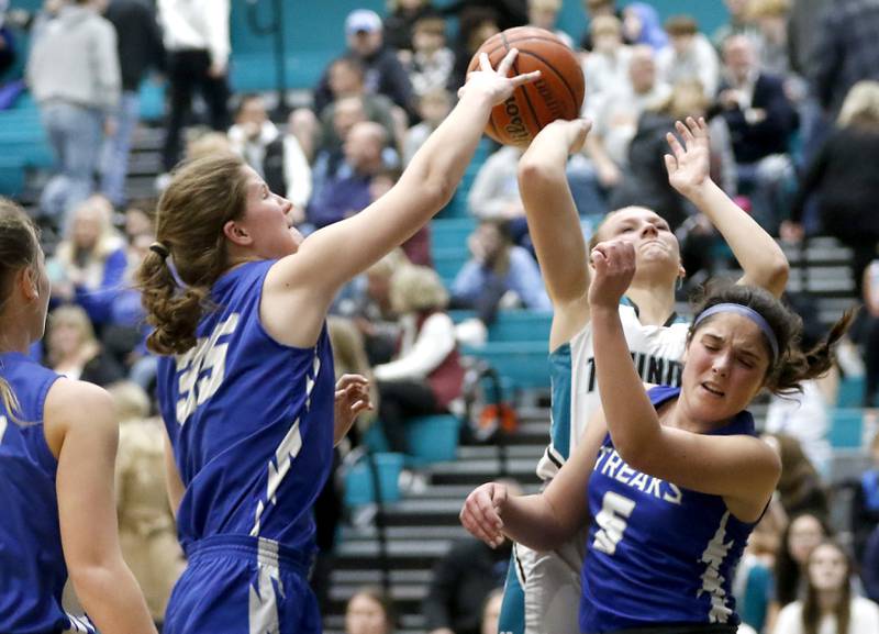 Woodstock's Anna Crenshaw blocks the shot Woodstock North’s Caylin Stevens as she drives to the basketball against Woodstock's Natalie Morrow during a Kishwaukee River Conference girls basketball game on Friday, Jan. 5. 2024, at Woodstock North High School.