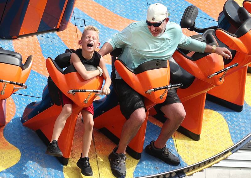 Connor Stoker, 8, and his dad Andrew, from DeKalb, ride one of the rides at the carnival during Corn Fest Friday, Aug. 25, 2023, in downtown DeKalb.