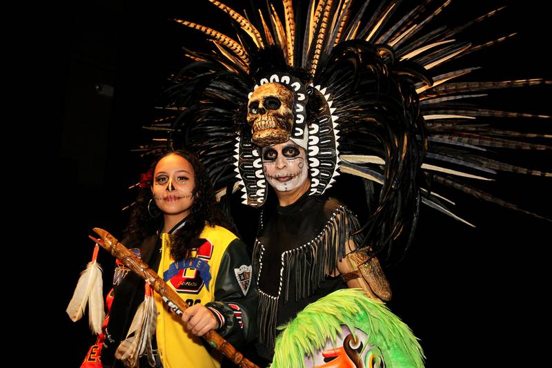 Natalia Quevedo, 19, of Round Lake takes a picture with Raul Cervantes, of Waukegan after he performed with the Tlacaelel Aztec Dance Group during the Day of the Dead Celebration at the Round Lake Beach Cultural & Civic Center.
