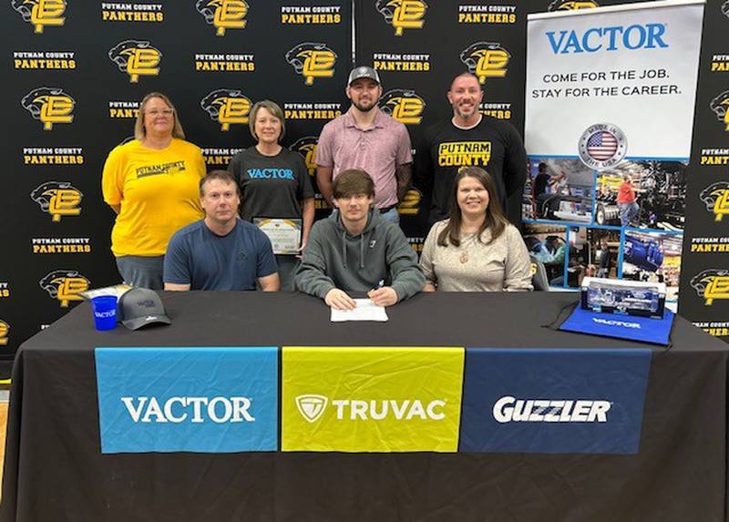 Ayden Lawless, a senior at Putnam County High School, sits with his parents and representatives from Vactor Manufacturing and the school following his signing with the company on Friday, May 16, after completing a yearlong internship through the school’s Work-Based Learning program.