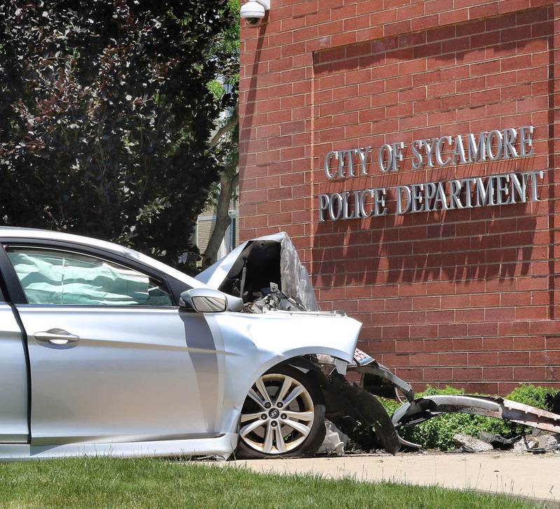 A car with heavy front end damage sits next to the front entrance of the Sycamore Police Department on DeKalb Avenue where it crashed into the building Wednesday morning, May 26, 2021. Police are investigating, and the cause of the crash remains unknown at this time. The crash sent the driver, a man, to Northwestern Medicine Kishwaukee Hospital with injuries.