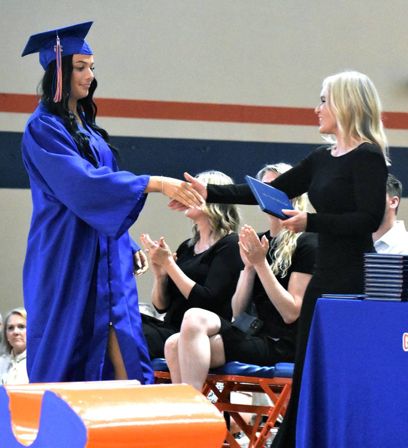Genoa-Kingston’s Zoe Boylen receives her diploma from School Board President Melyssa Gustafson Sunday, May 17, 2026, during the commencment ceremony at Genoa-Kingston High School.