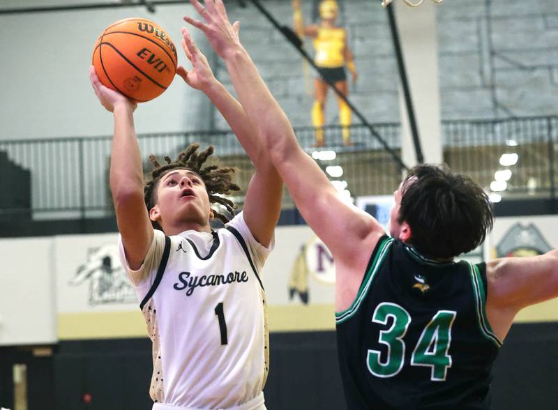 Sycamore's Josiah Mitchell goes to the basket against North Boone's Ronnie Ragland during their game Tuesday, Dec. 3, 2024, at Sycamore High School.