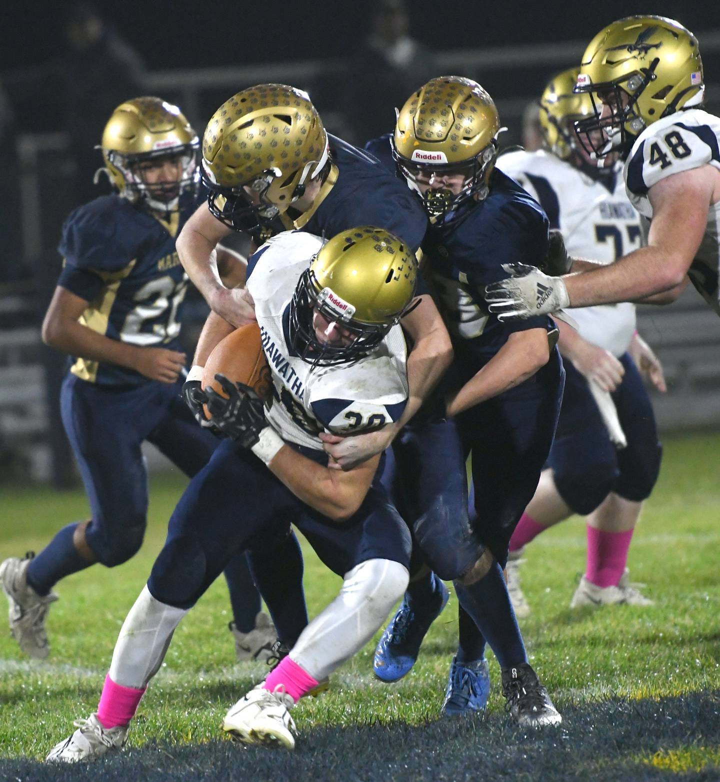 Hiawatha's Cooper Fisher is tackled by two Polo players during 8-man playoff action on Friday, Oct. 28.