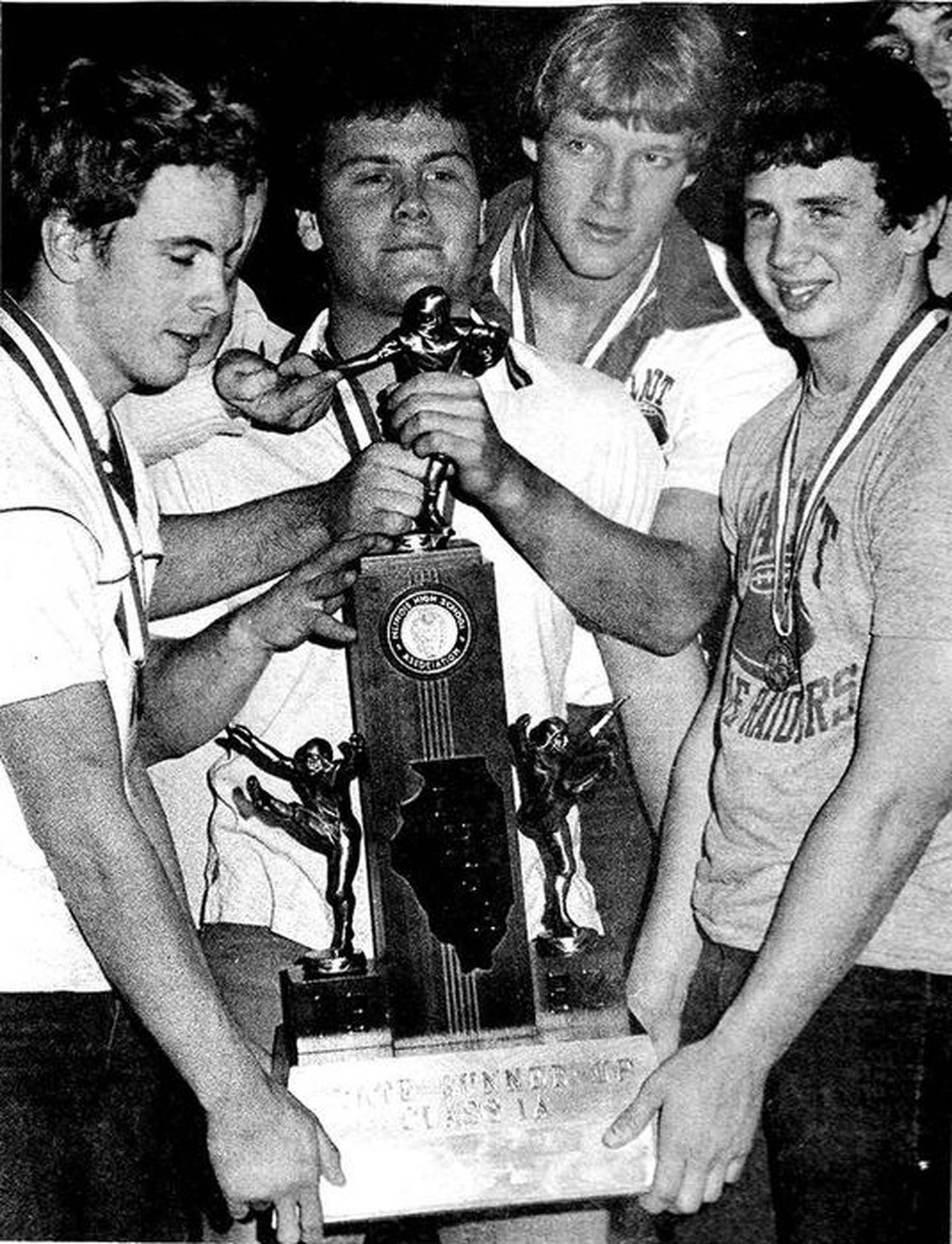 Jeff Holaway, Doug Christiansen, Ken TerBush and Rick VonHolten of the 1982 Walnut Blue Raiders football team show off their IHSA Class 1 State runner-up trophy at the community welcome-home celebration in Walnut.