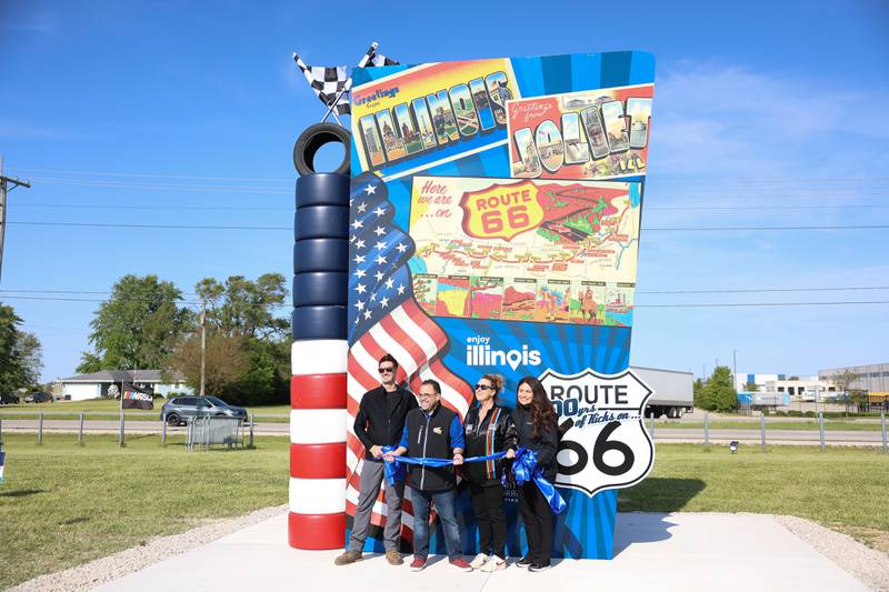 Artist Tim Harmon, left, stands with others for the ceremonial ribbon at the unveiling of his new Route 66 sculpture along South Chicago Street at the Route 66 Raceway on Tuesday, May 12, 2026 in Joliet.