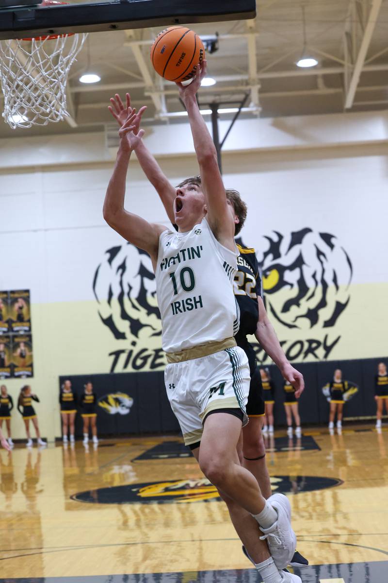 Bishop McNamara's Coen Demack puts in a layup under pressure during Bishop McNamara's 71-42 victory over Herscher in the IHSA Class 2A Herscher Regional semifinal on Wednesday, Feb. 25, 2026.