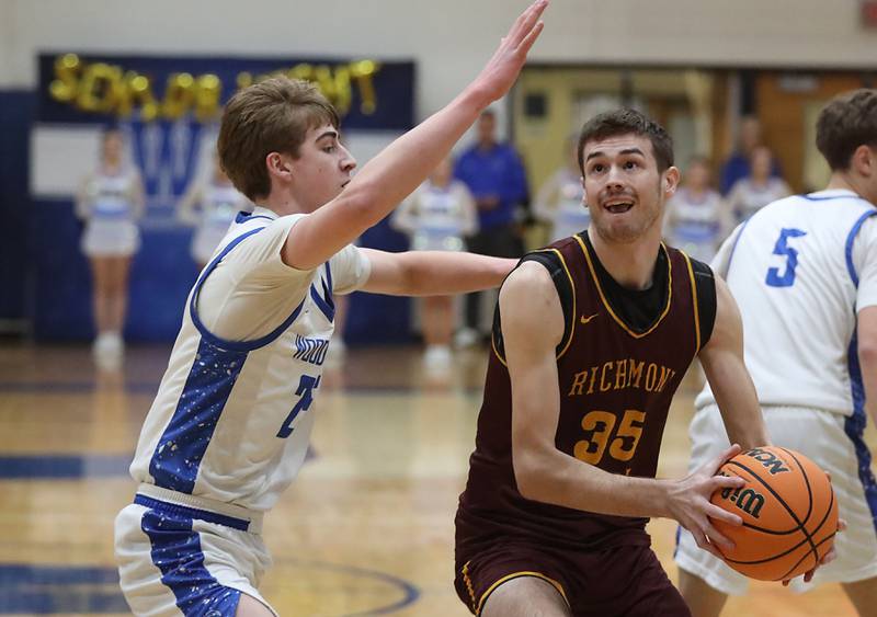 Richmond-Burton's Jace Nelson (right) drives to the basket against Woodstock's Liam Laidig during a Kishwaukee River Conference boys basketball game on Wednesday, February. 4, 2026, at Woodstock High School.