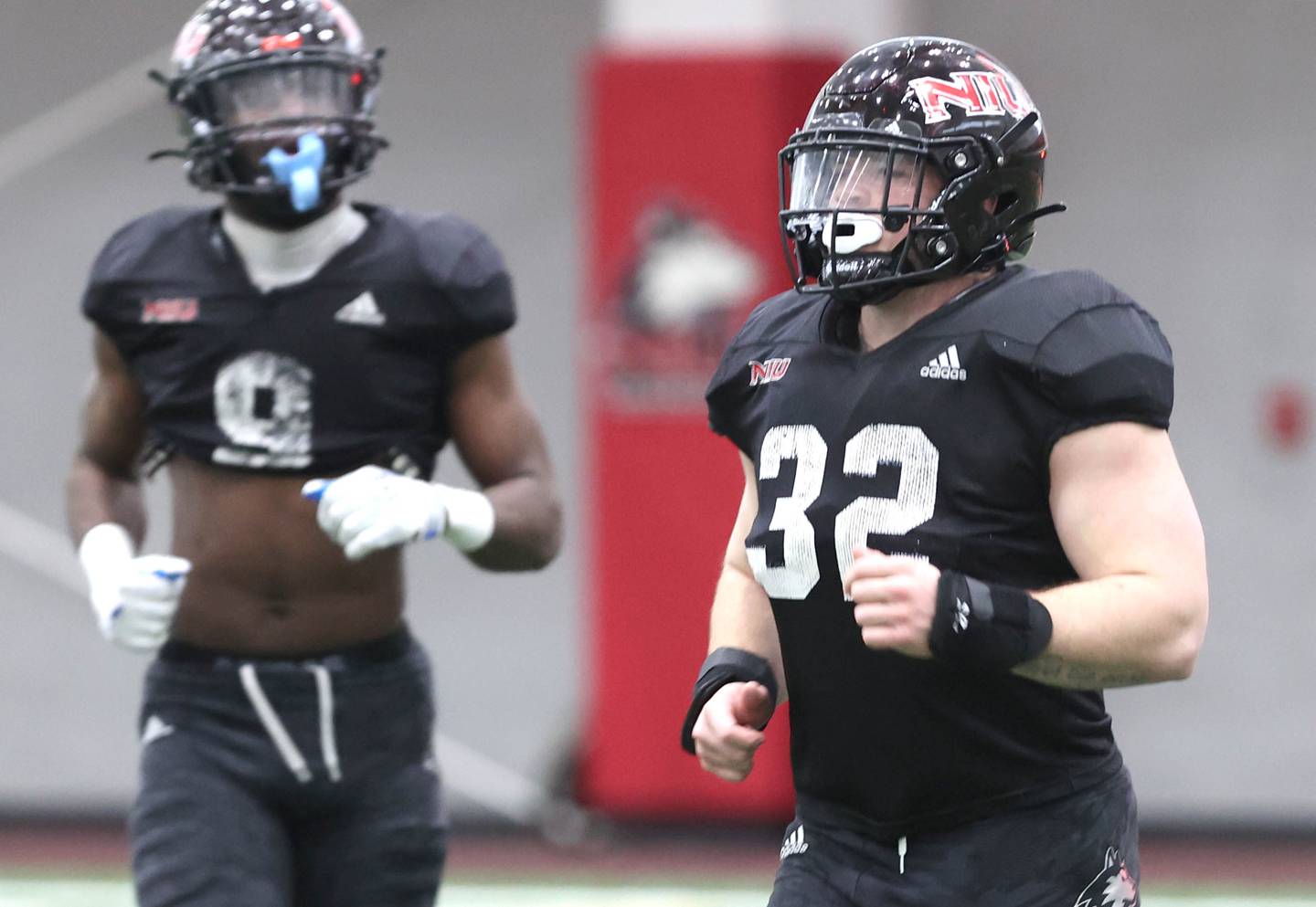 Northern Illinois University linebacker Quinn Urwiler (right) runs on the field Wednesday, March 30, 2022, during spring practice in the Chessick Practice Center at NIU in DeKalb.