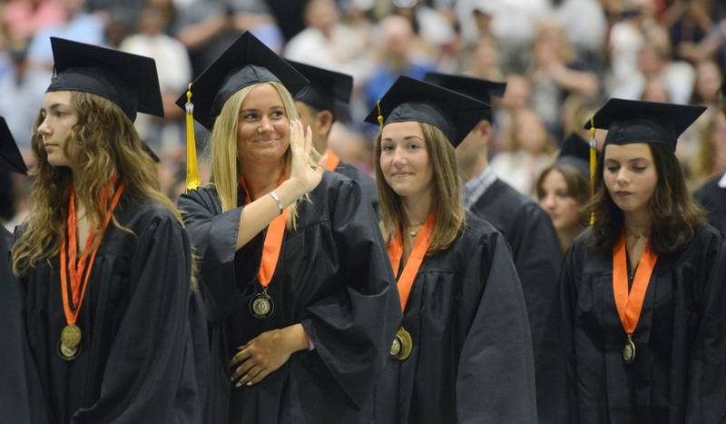 Joe Lewnard/jlewnard@dailyherald.com
A graduate waves to her family during processional of the Wheaton Warrenville South High School graduation, held at the College of Dupage in Glen Ellyn Saturday.
