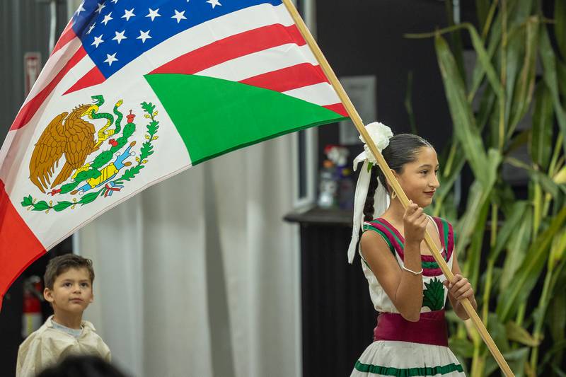 Nayeli Carbajal waves a split USA and Mexico flag after dance performance at the 'Where Our Paths Meet' screening event on Sunday, Sep 7, 2025 at Diaz Banquet Center in Mendota.