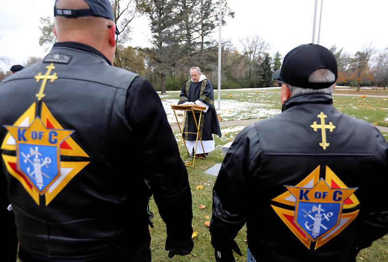 Deacon Ken Giacone, from St. Elizabeth Ann Seton Catholic Church in Crystal Lake, speaks during the Veterans Day flag placement ceremony Tuesday, Nov. 11, 2025, at the gravesites of veterans at McHenry County Memorial Park Cemetery in Woodstock. Members of the Knights of Columbus Patriotic 4th Degree from the Bishop Boylan Assembly placed American Flags at nearly 140 veterans' grave markers.