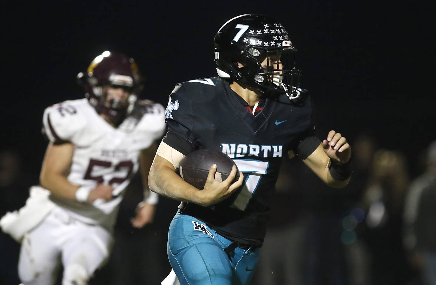 Woodstock North's Parker Halihan runs with the ball as Richmond-Burton's Bryce Kowall give chase during a Kishwaukee River Conference football game on Friday, Oct. 10, 2025, at Woodstock North High School.