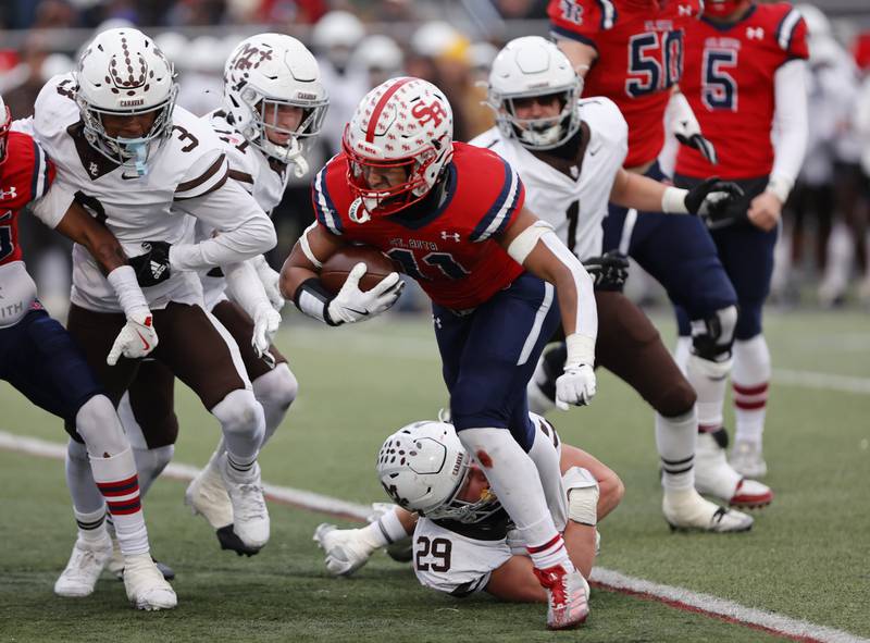 St. Rita's Justin Buckner (11) is caught by Mt. Carmel's Stephan Winkler (29) during the class 7A semi-final playoff game between Mt. Carmel and St. Rita high schools on Saturday, Nov. 23, 2024 in Chicago.