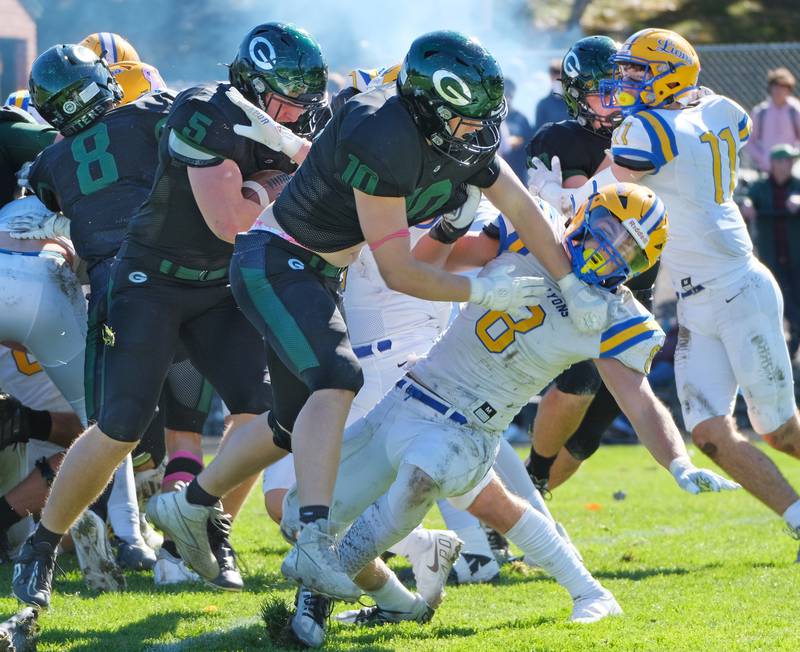 Glenbard West's Jack Oberhofer (5) powers to the end zone behind a block by Brandon Kud (10) on Lyons Township's Danny Pasko during a game on Oct. 15, 2022 at Glenbard West High School in Glen Ellyn.