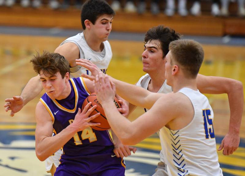 Downers Grove North's Maxwell Haack (14) tries to escape the crush of Lyons Township defenders (from left) Carter Reid, Matthew DeSimone, and Graham Smith (15) during a game on Jan. 6, 2023 at Lyons Township High School in LaGrange.
