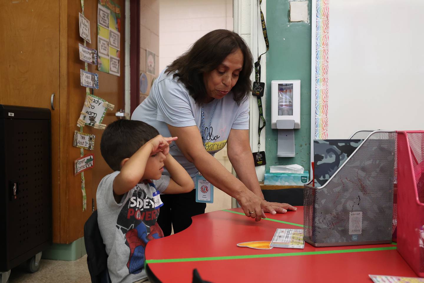 Paraprofessional Estela Paroma works with Ryan Nevarez on his first day of kindergarten at Taft Elementary on Wednesday, Aug. 16, 2023 in Joliet.