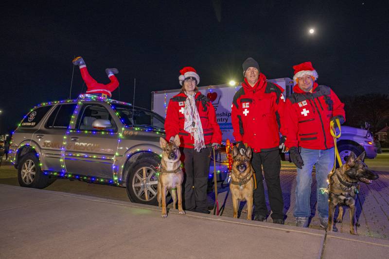 Members and K9's (left to right) Joann Schweickert with Britta, Jason Schweickert with Nikita, and Jaime Piano with Zena represent Central Illinois Search and Rescue during the parade in Spring Valley on November 25, 2023.