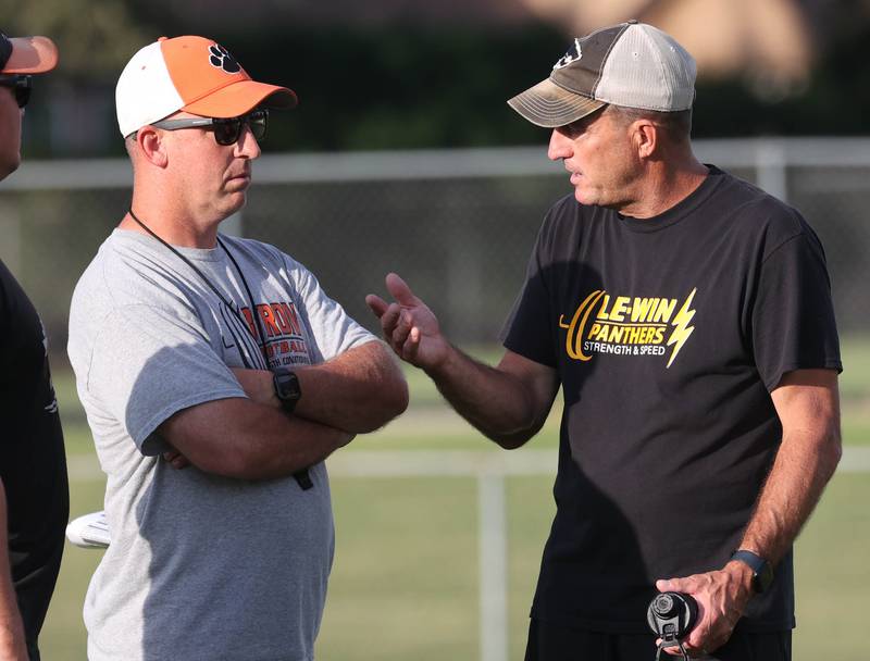 Byron head football coach Jeff Boyer (left) talks to Lena-Winslow head coach Ric Arand Thursday, July 24, 2025, during a joint practice with Byron, Lena-Winslow and Sycamore at Sycamore High School.