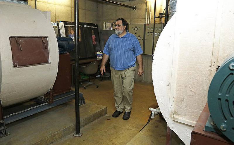 H. Rick Bamman – hbamman@shawmedia.com
Crystal Lake Library custodian Dan Puzzo walks through the central utility room Friday, July 22, 2016, that houses the air system for the building. Obsolete cage fans circulate the air in the all-electric building. Parts for the ventilation equipment are hard to find or no longer available. The Crystal Lake City Council voted unanimously to place an advisory referendum on the November ballot asking city voters if they would be willing to pay $30 million to build a new library at the existing site on Paddock Street.
