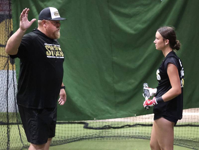 Sycamore Sycos 16u softball coach Ryan Knox gives some swing pointers to Kendall Wolf Wednesday, June 18, 2025, in the batting cage at their indoor practice facility in DeKalb.