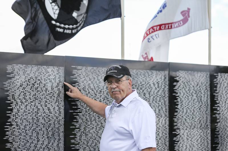 Wayne Horne who fought in the 101st Airborne division, locates a friend's name, who fell in battle at the Vietnam Traveling Memorial Wall Thursday, Aug 21, 2025  in Romeoville.