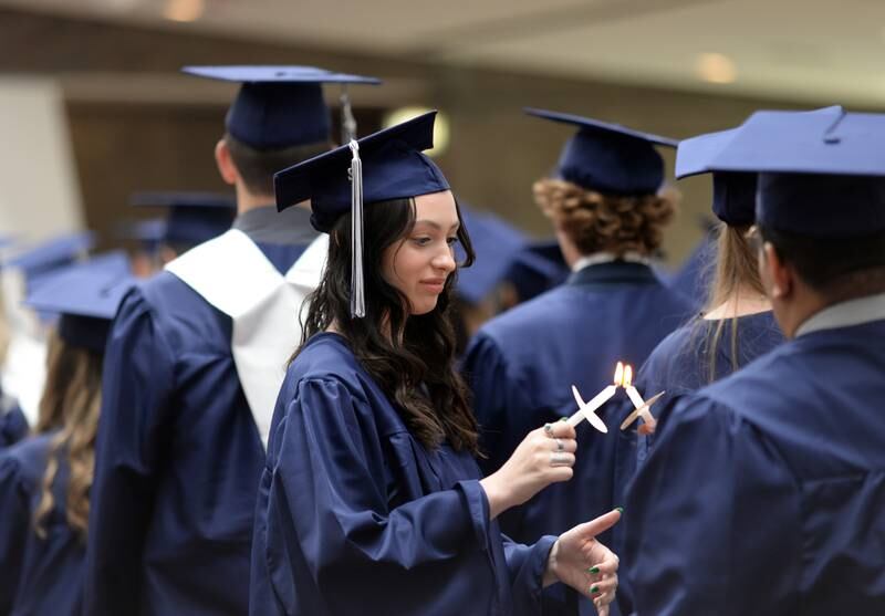 Nazareth class of 2022 students Julia Tita of Berwyn light candles during their mass prior to their graduation Sunday May 22, 2022.