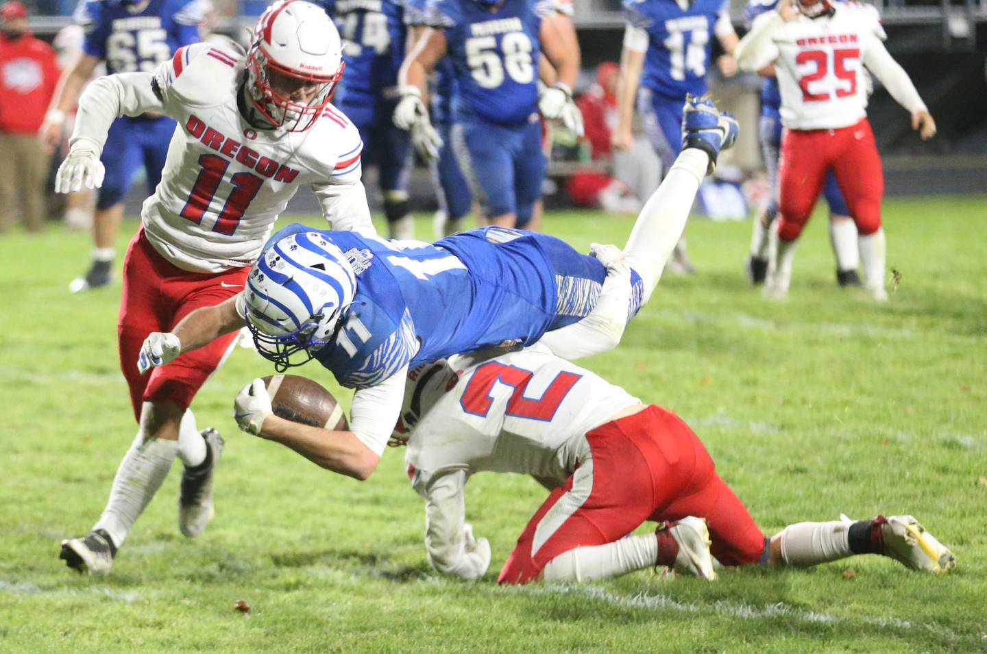 Princeton's Noah LaPorte dives over Oregon's Cooper Johnson to gain a few extra yards during the Class 3A playoff game on Friday, Nov. 1, 2024 at Princeton High School.