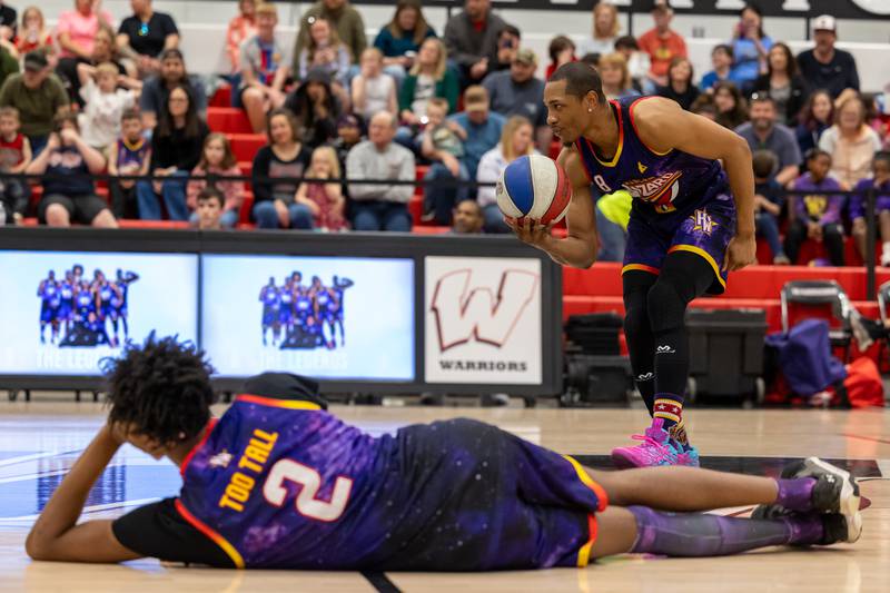 Devon “Livewire” Curry (8) of the Harlem Wizards “pitches” basketball to “batter” Arnold “A-Train” Bernard (9) on Wednesday, April 16, 2025 at Woodland High School in Streator.
