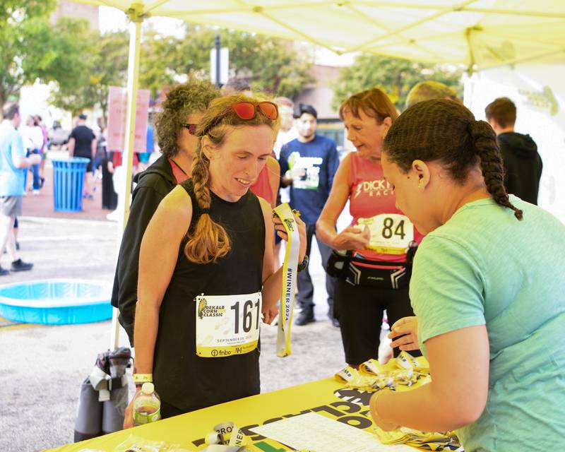 Lynnette Danzl-Tauer receives her medal after placing 2nd in her age group on Sunday, Sept. 29, 2024, during the DeKalb Corn Classic 5K/10K race downtown.