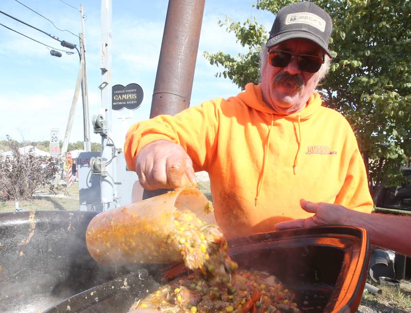 Volunteer Nathan Miller of Eureka dumps a pitcher of Burgoo into a pan during the 54th annual Burgoo on Sunday, Oct. 13, 2024 downtown Utica.