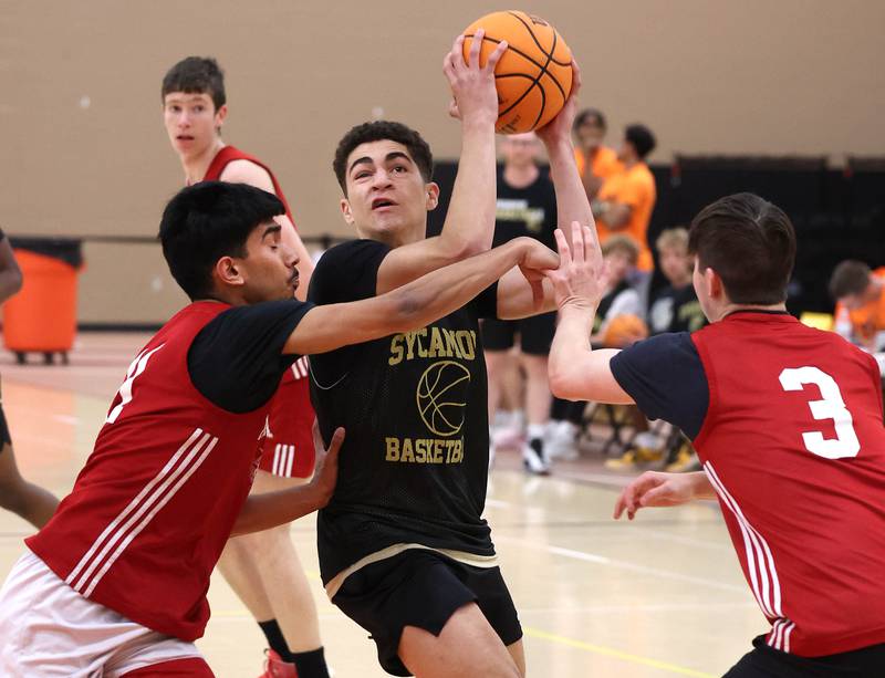 Sycamore’s Marcus Johnson slits a double team Friday, June 20, 2025, during their game against Marmion in the DeKalb Live summer tournament at DeKalb High School.