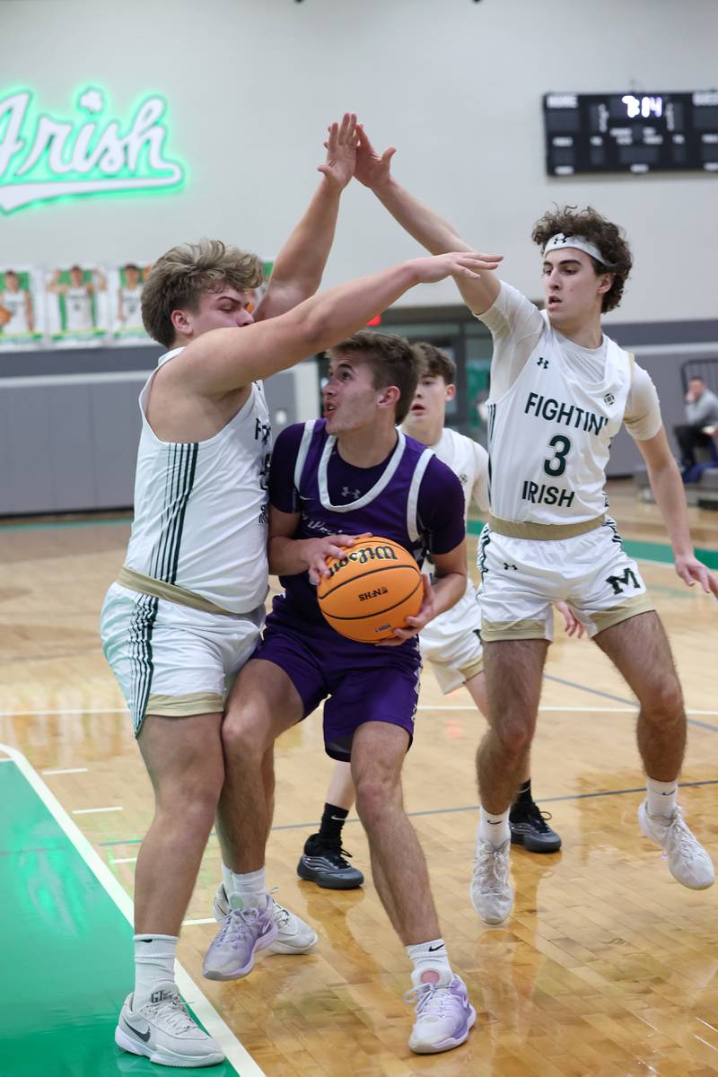 Bishop McNamara's Ian Irps stops a drive by Wilmington's Brysen Meents during Bishop McNamara's 61-24 victory over Wilmington in the IHSA Class 2A Seneca Sectional semifinal on Tuesday, March 3, 2026.