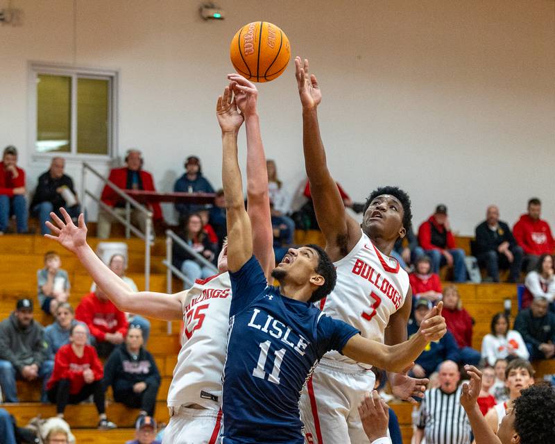Lisle's David Nesbitt (11) and Streator's Joseph Hoekstra (25) of Streator and teammate Samuel LeRette (3) leap for rebound on Wednesday, Feb. 18, 2026 at Streator High School in Streator.