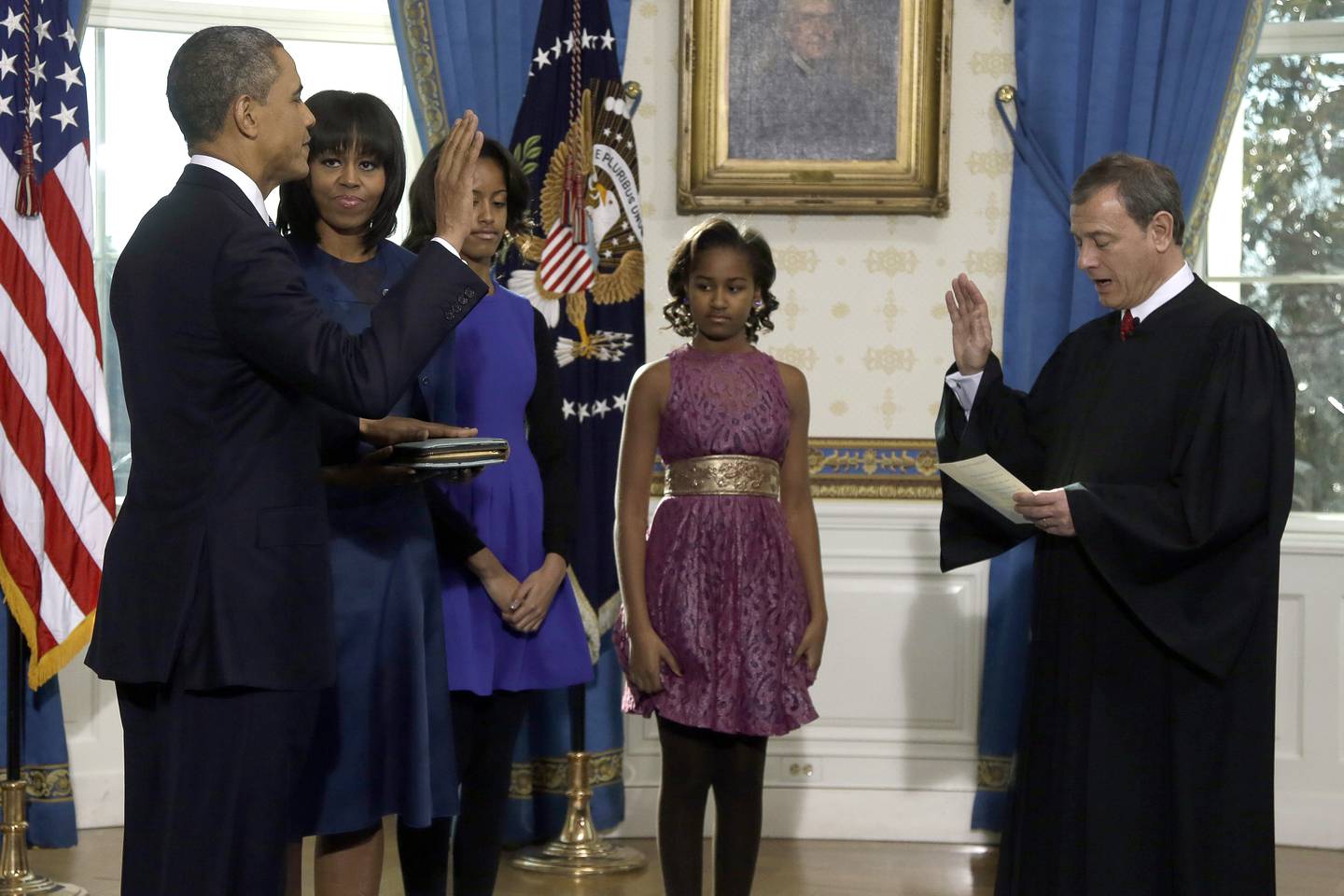 In this Jan. 20, 2013, file photo, President Barack Obama is officially sworn in by Chief Justice John Roberts in the Blue Room of the White House during the 57th Presidential Inauguration in Washington. Next to Obama are first lady Michelle Obama, holding the Robinson Family Bible, and daughters Malia and Sasha.