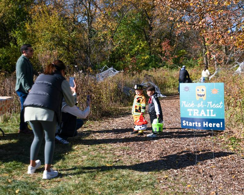 Friends Lucas Barbato, 3, of Glen Ellyn and Finnley Turner, 3, of Glen Ellyn pose for a photo for their parents on Saturday Oct. 26, 2024, before entering the Boo Bash trail Ackerman Park in Glen Ellyn.