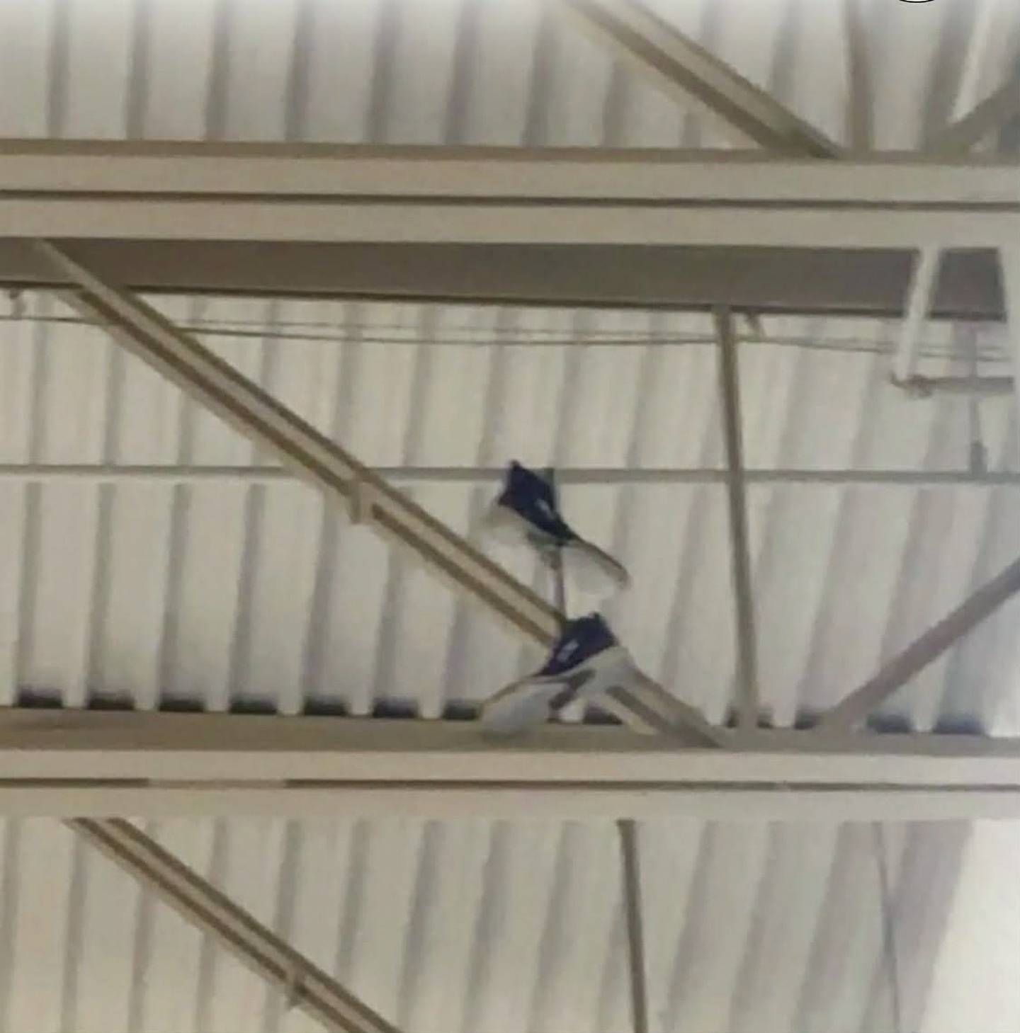 The shoes belonging to the late Wilmington wrestling coach Nick Dziuban are shown hanging from the rafters in the wrestling gym at Wilmington High School. Teammates gathered to remember their late coach on Feb. 3, 2026, tossing his shoes into the rafters of the wrestling practice gym where they will remain in his honor.
