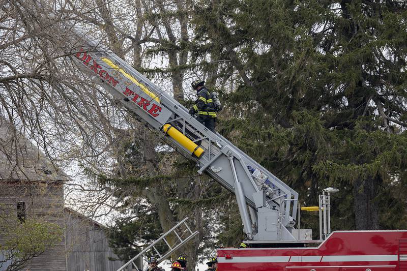 A firefighter climbs the Dixon snorkel Monday, April 14, 2025, to battle a fire on Harmon Road.