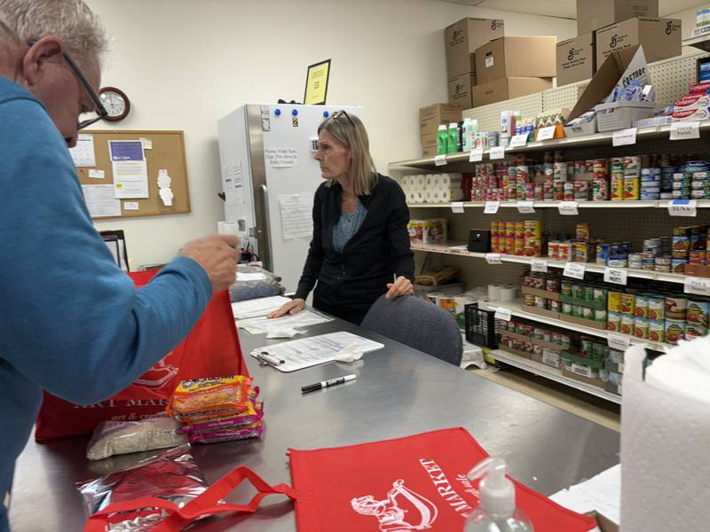 Woodstock Food Pantry board president Bruce Thacker, left, packs food at the pantry Oct. 31, 2025.