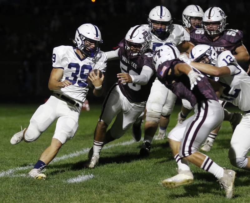 Cary-Grove’s Holden Boone runs with the ball as he is chased by Prairie Ridge's Jose Esparza during a Fox Valley Conference football game on Friday, Sept. 27, 2024, at Prairie Ridge High School.