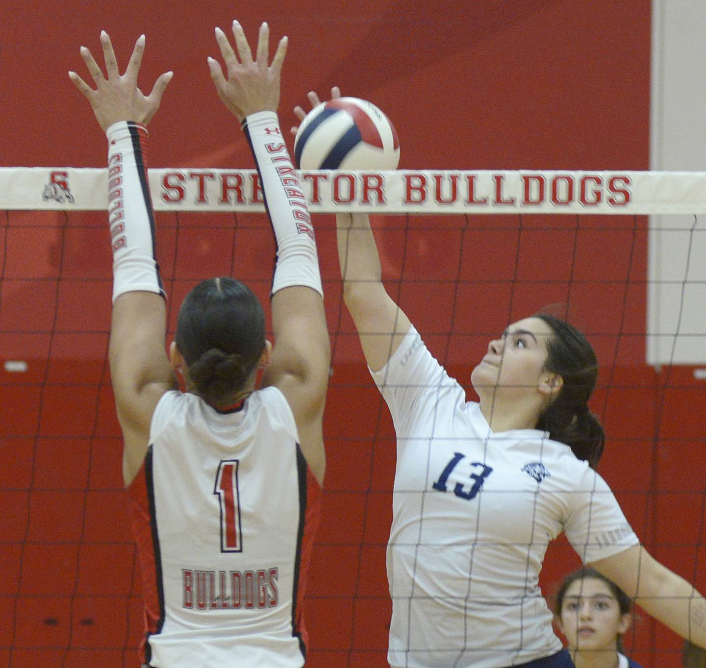 Lisle’s Sophia Harer reaches to get the ball past Streator’s Aubrey Jacobs , who sets to block in the 2nd set Tuesday during match at Streator.