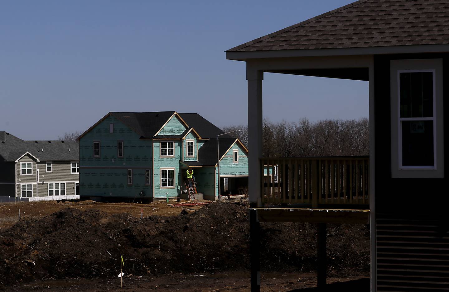 Construction workers work on building a house on Glengary Court Circle Monday, March 28, 2022, in the Woodlore Estates subdivision.