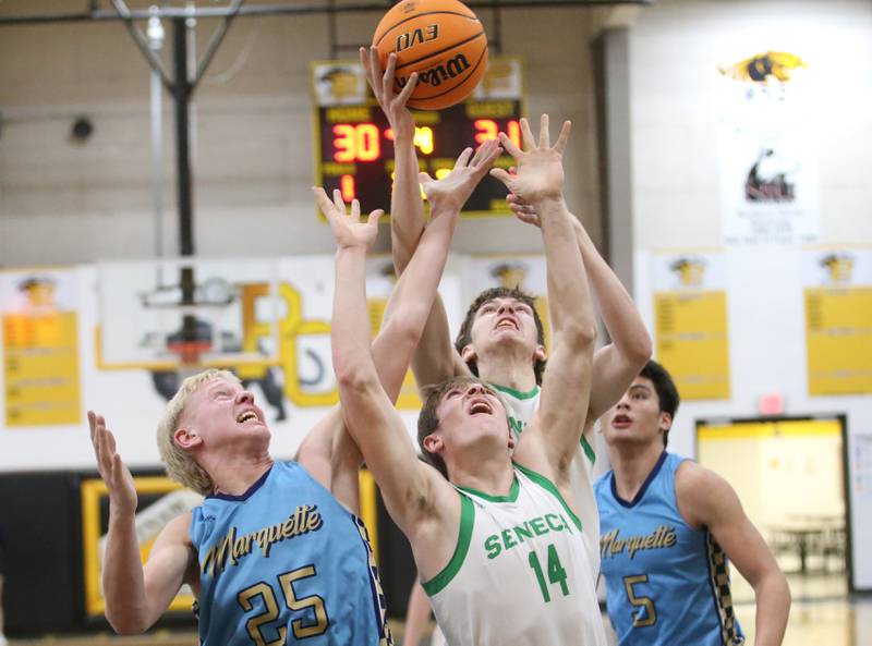Seneca's Patrick Griffin (top) and Cameron Shriey (bottom grab a rebound over Marquette's Luke McCullough (left) during the Tri-County Conference championship on Friday, Jan. 31, 2025 at Putnam County High School.